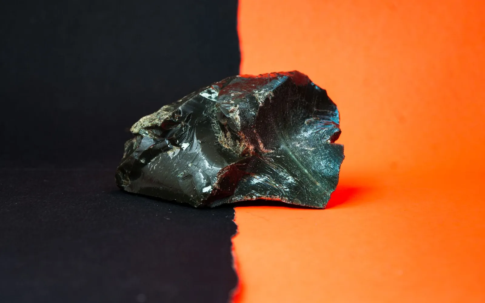 Un éclat d’obsidienne sur un fond noir et orange